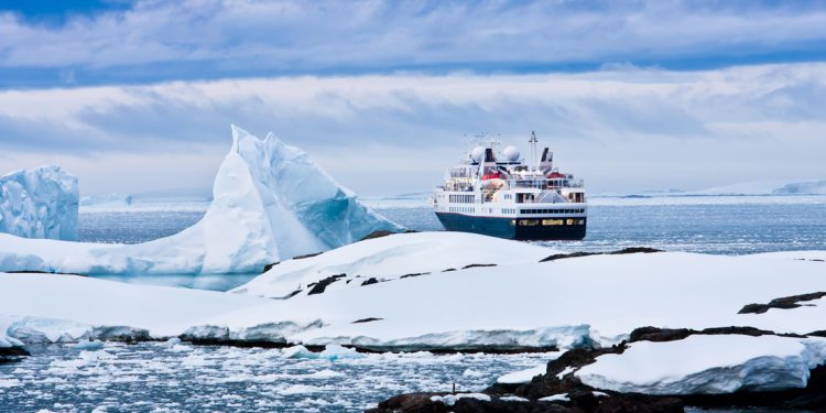 cruise ship in icy waters seen passing glaciers and icebergs