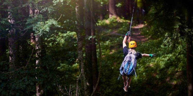 Woman ziplining through the forest