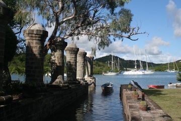 Pillars leading into water with sailboats in background