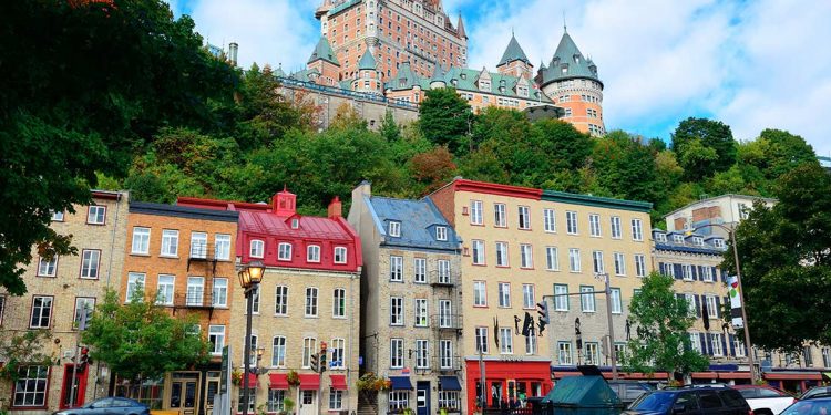 Colorful buildings with hotel on hill in background