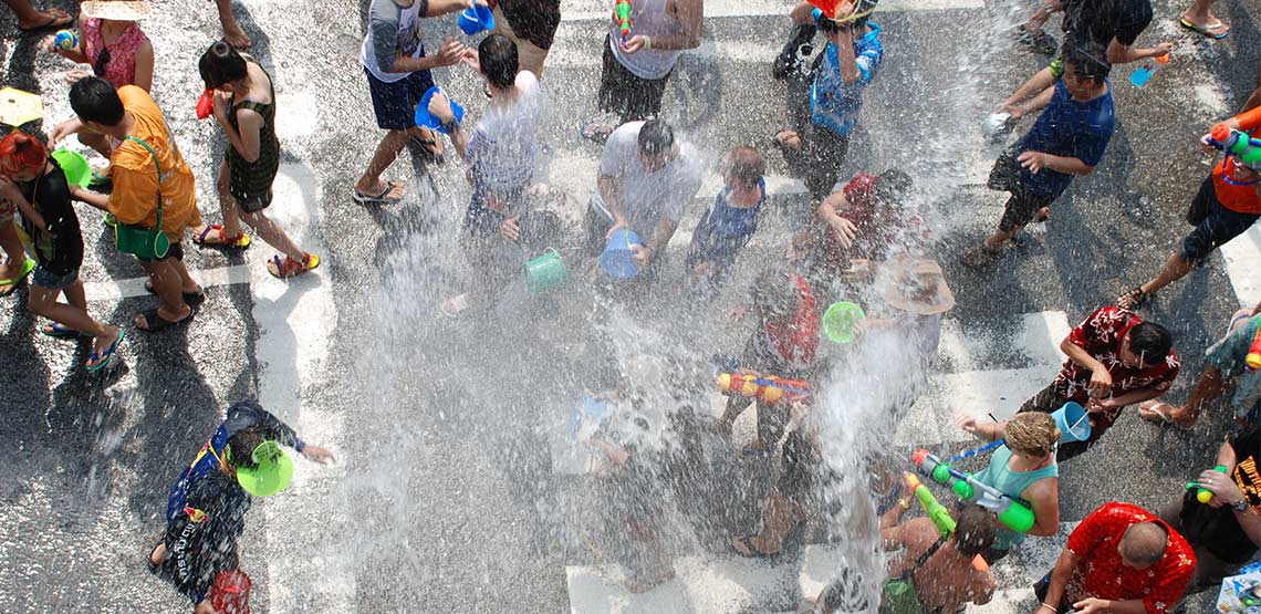 Overhead view of people in streets with buckets of water and water guns.