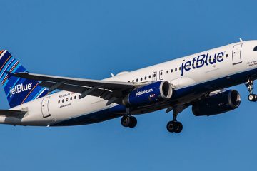 JetBlue jet taking off against a deep blue sky