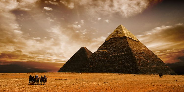 dramatic sunset behind the pyramids