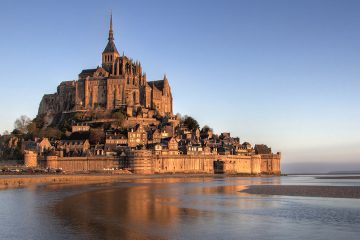 Mont St Michel bathed in the warm glow of a sunset
