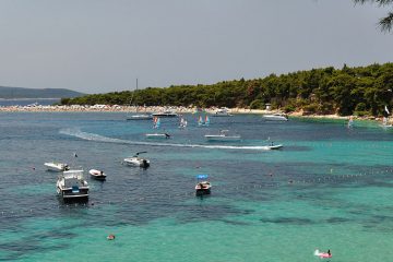 aerial view of boats in a bay and a sandy beach