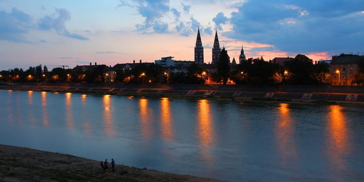 city lights from Szeged reflect in the water at sunset