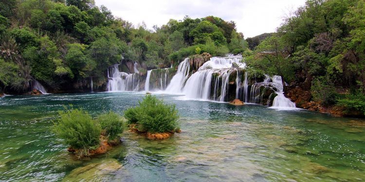 people swimming and playing in waterfalls at Krka National Park