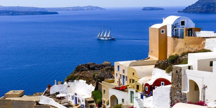 tall ship sets sail on the coastline of Santorini in Greece