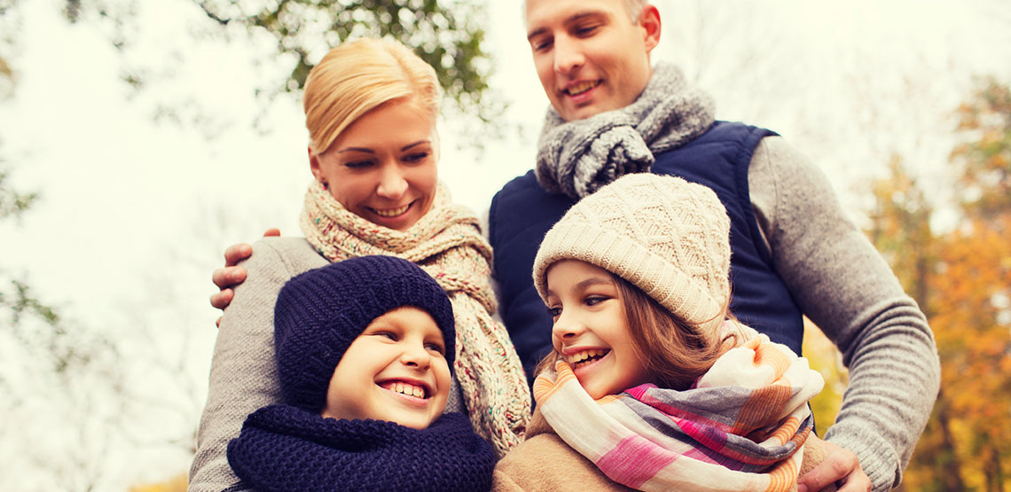 happy family bundled in knit winter accessories