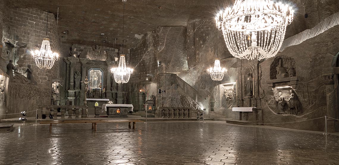 chandeliers hang in a stone room of a salt mine