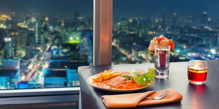 a meal sits on a table overlooking the city at night