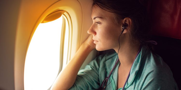 Woman staring out window of plane.