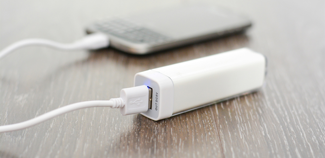 white portable charger connected to mobile phone