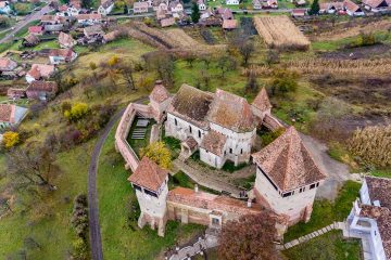 old fortified church in Romania surrounded by forest.