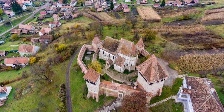 old fortified church in Romania surrounded by forest.