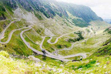 Winding roads of the Transfagasaran Highway with clouds and mountains in background