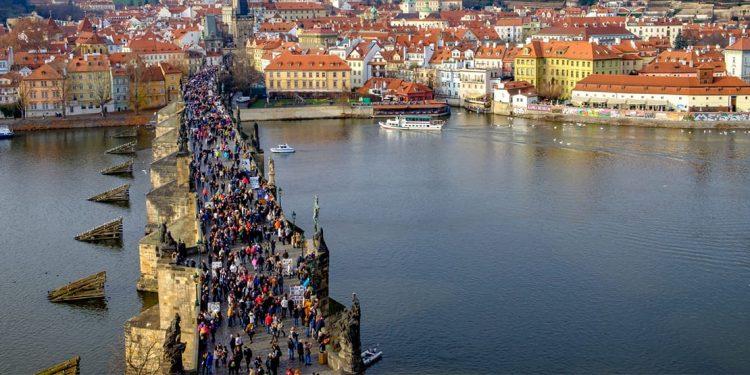 An aerial view of hundreds of people on the Charles Bridge, Prague