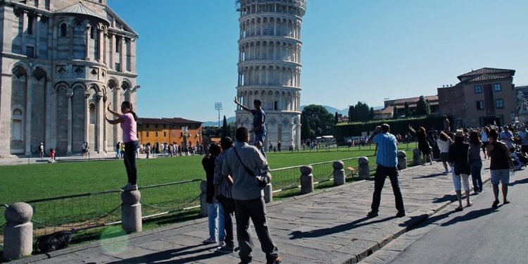 Tourists take photos of the Leaning Tower of Pisa