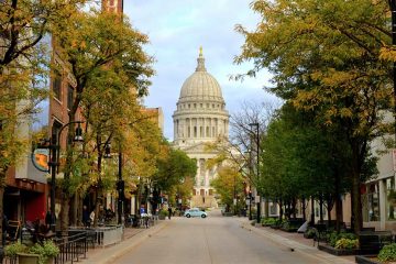 The Wisconsin State Capitol building at the end of a street lined with trees