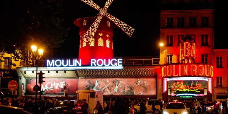 The Moulin Rouge's iconic windmill lit up at night