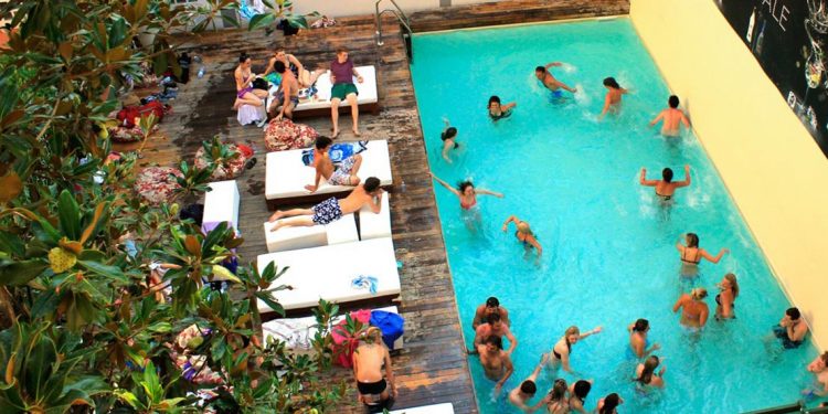 People enjoy the swimming pool at Plus Florence hostel