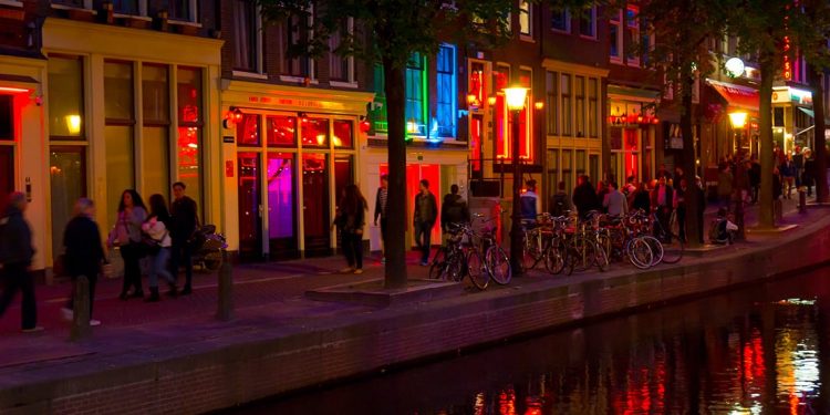 The exterior of Amsterdam's Sex Museum, lit up in different colors at night