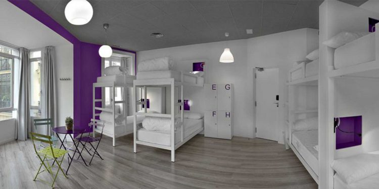 Inside a modern U Hostel room with bunkbeds and purple and white decor