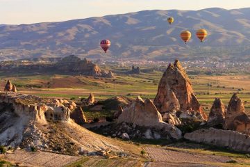 rock formations of cappadocia with hot air balloons in the sky