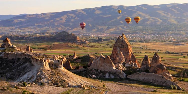 rock formations of cappadocia with hot air balloons in the sky