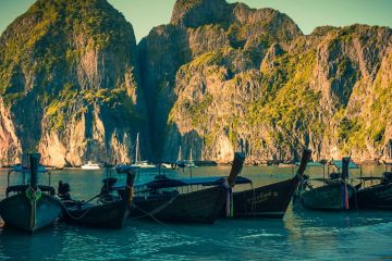 boats surrounded by mountains in maya bay thailand