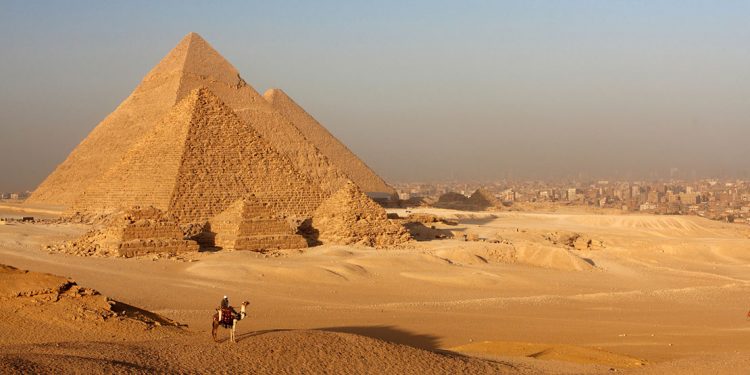 pyramids of giza with city encroaching behind