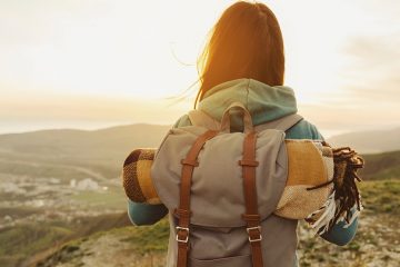 traveler with backpack overlooking mountains