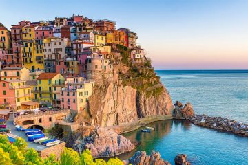 colorful houses stacked along a rocky coast