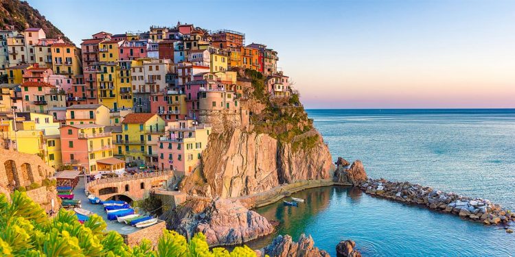 colorful houses stacked along a rocky coast