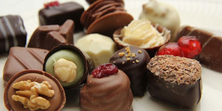 a variety of chocolate treats on a white surface