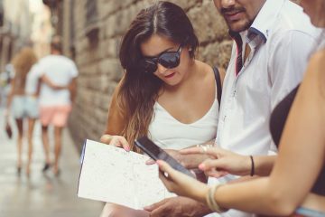 group of people comparing paper map and smartphone
