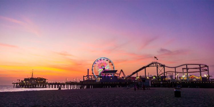 roller coasters and festival rides at Santa Monica pier at sunset