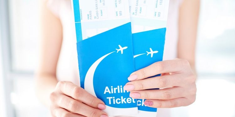 woman holding two airline tickets
