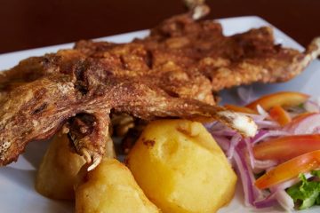 fried guinea pig over potatoes with side of vegetables