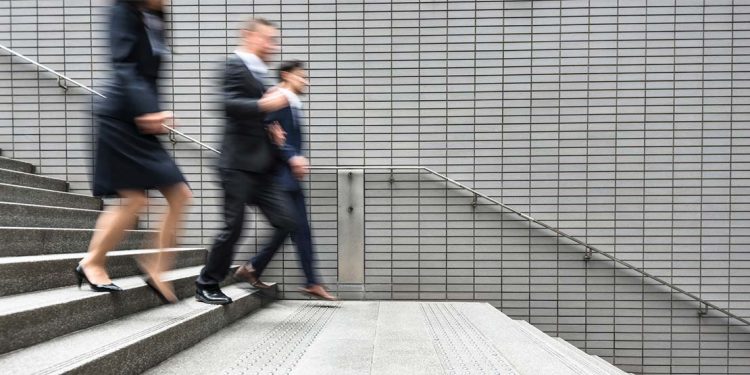 people in business attire running down stairs
