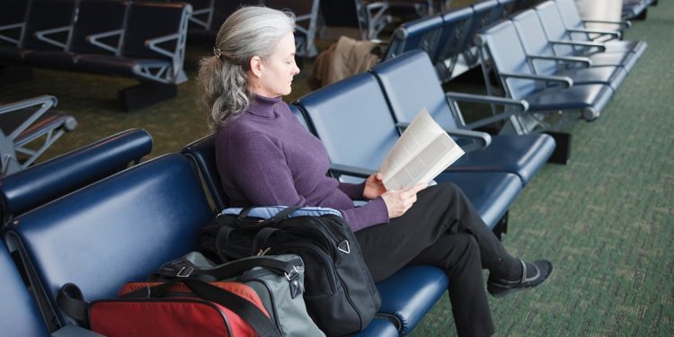 mature woman reading in airport