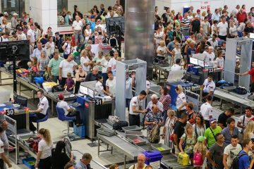 Overhead shot of hundreds of people making their way through airport security