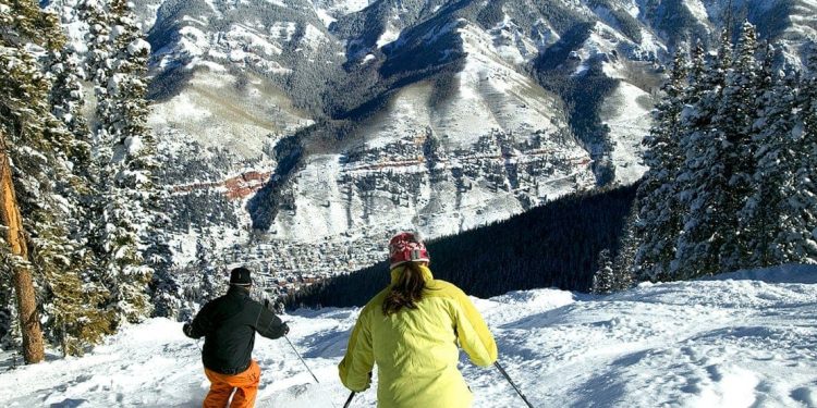 Two people ski down a steep hill at Telluride, Colorado, USA