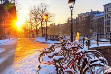 Bikes parked in an Amsterdam street covered with snow
