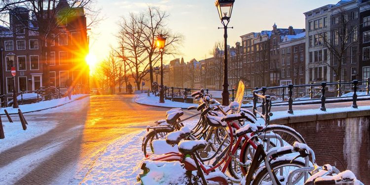 Bikes parked in an Amsterdam street covered with snow