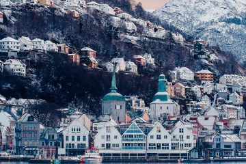 Snow covered buildings in Bergen, Norway, with a mountain in the background