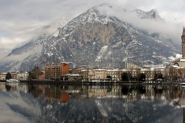 Snow dusted buildings and mountains viewed from Lake Como