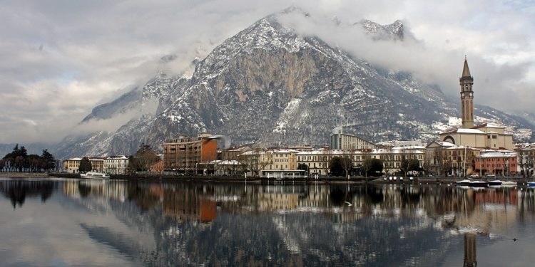 Snow dusted buildings and mountains viewed from Lake Como