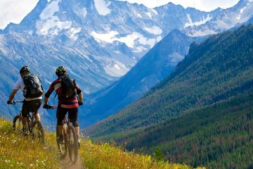 people riding bikes through the mountains