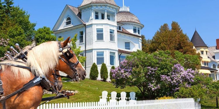 Two carriage horses in front of an historic home in Mackinac Island
